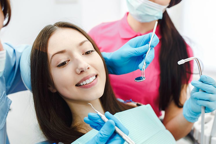 Assistant dentist and the patient in the clinic.